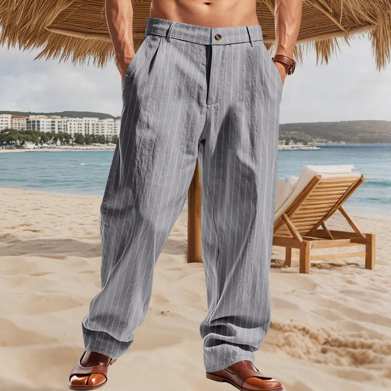 Man wearing loose-fit high-waist striped linen trousers in a light blue colour.