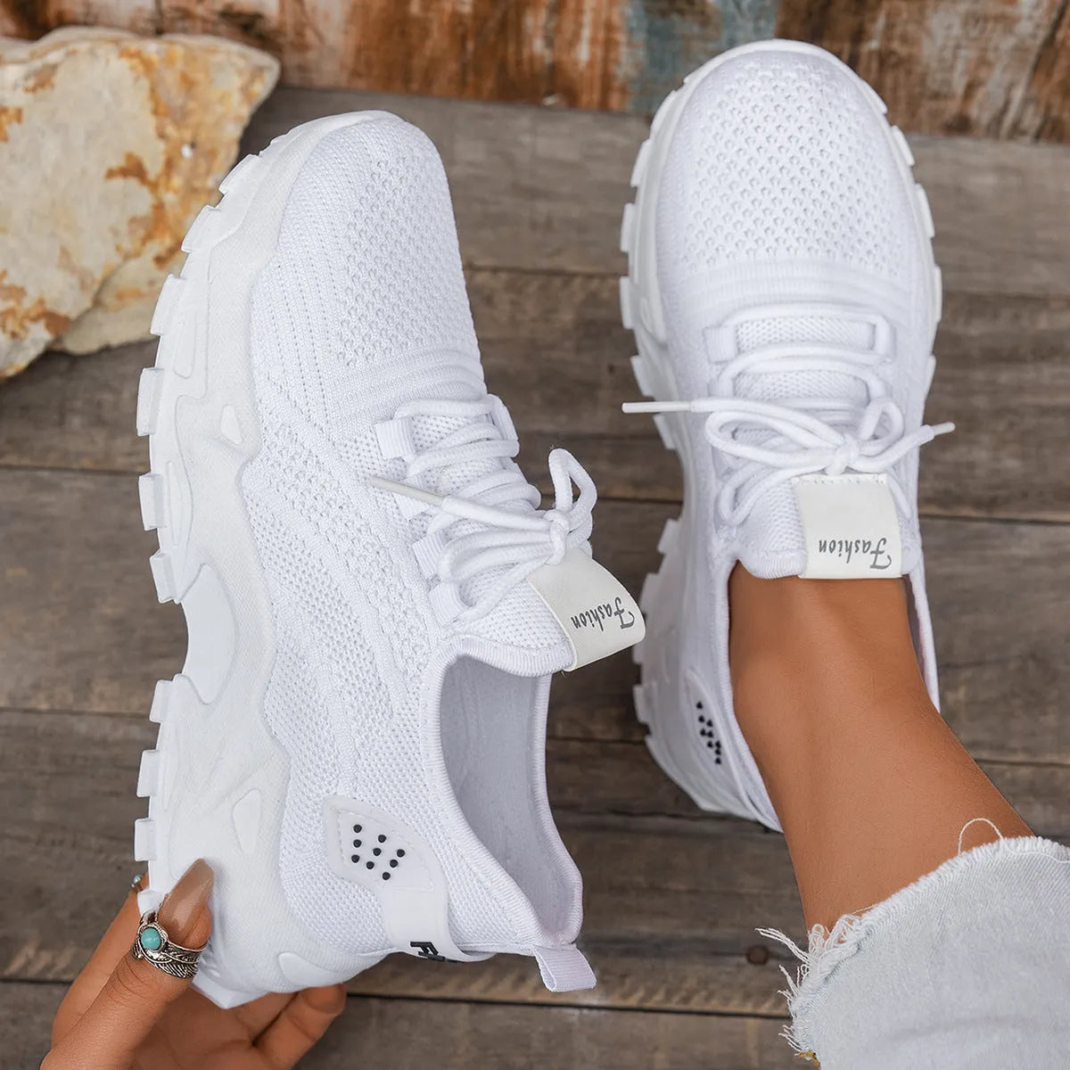 Women's white Flyknit mesh casual sports shoes with flat heel and lace-up front.
