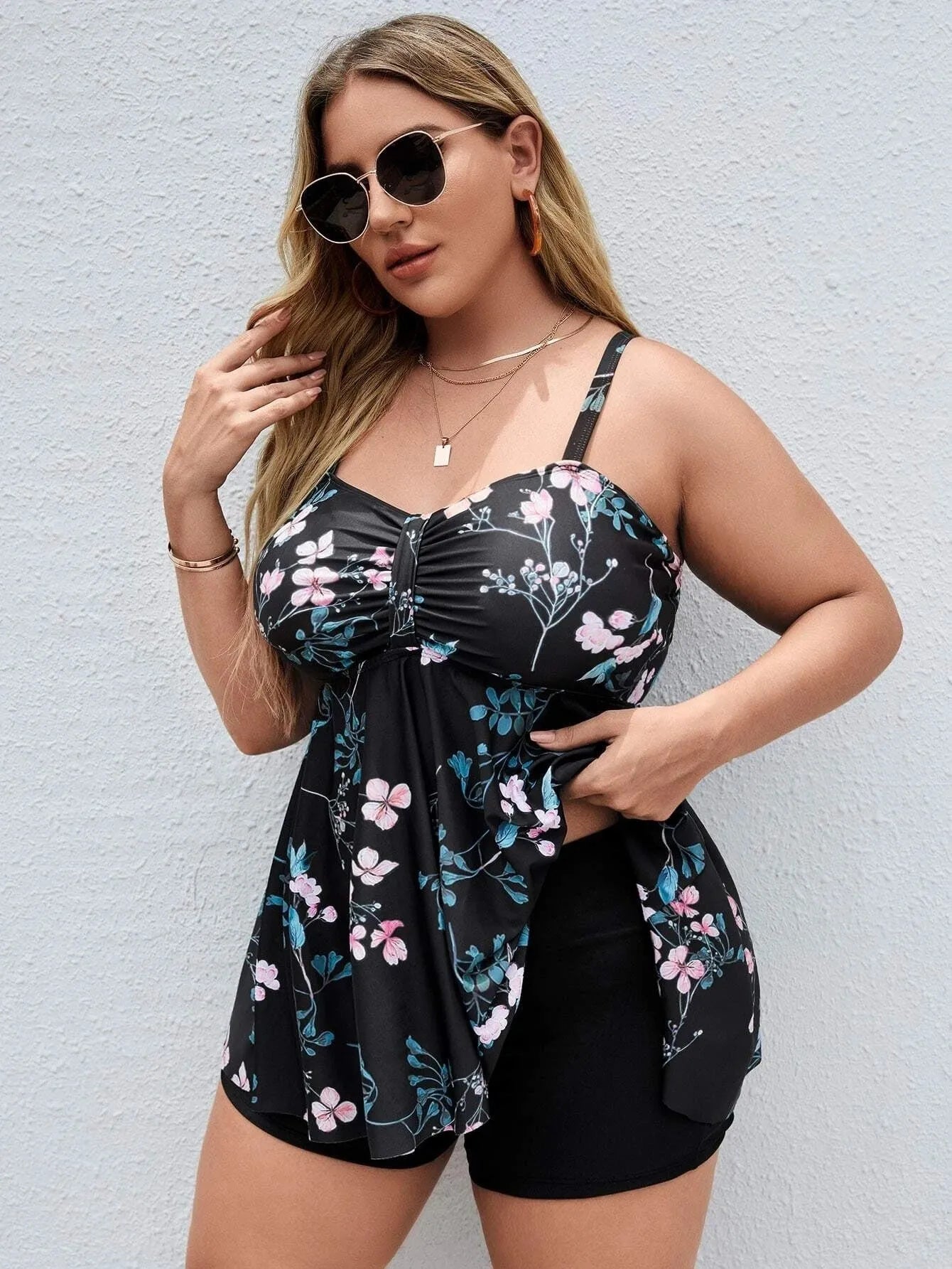 Women's floral print one-piece swimsuit on a hanger, showing split colour design and available in sizes 0XL to 4XL.