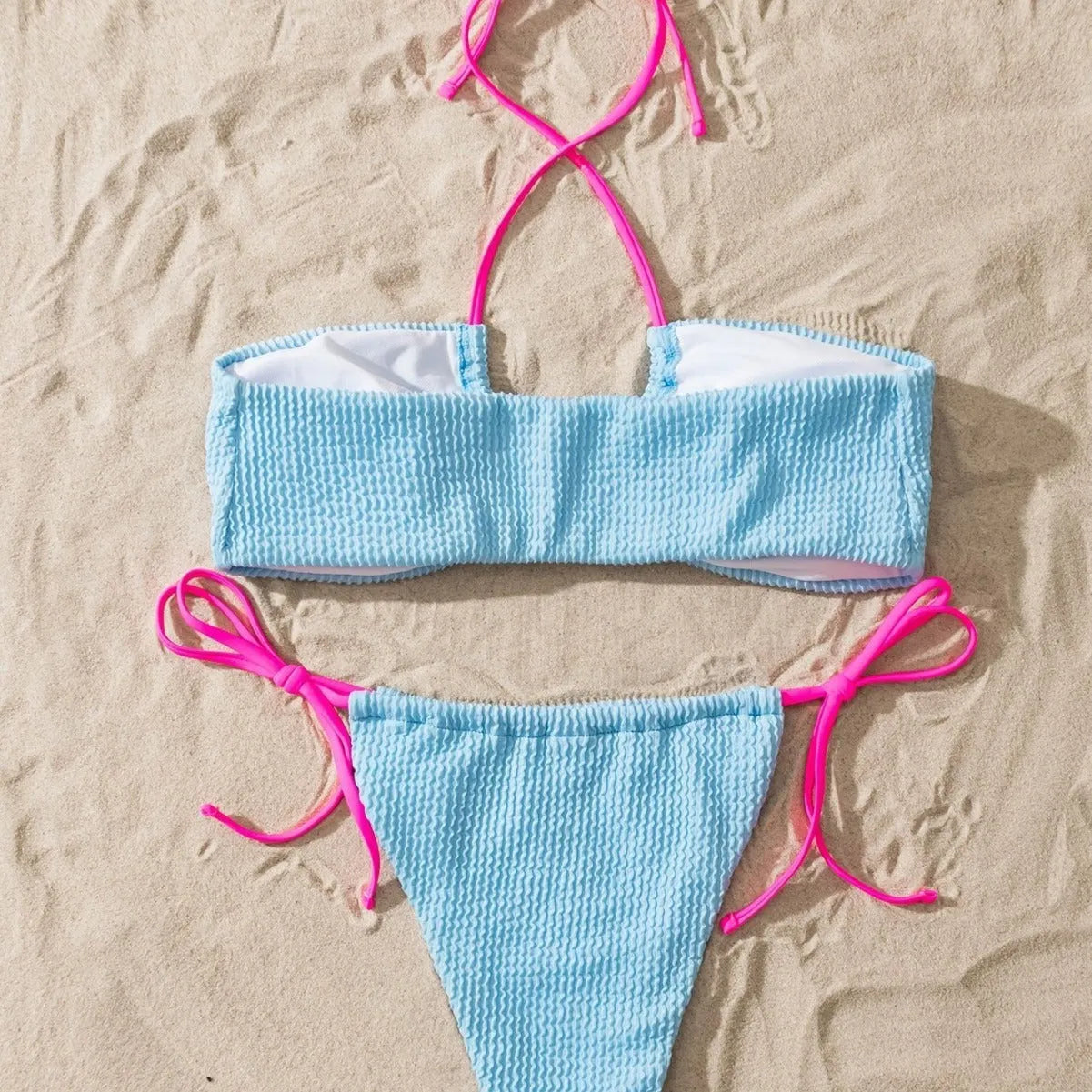 Solid colour women's two-piece swimsuit with halter lace-up top and briefs on a model