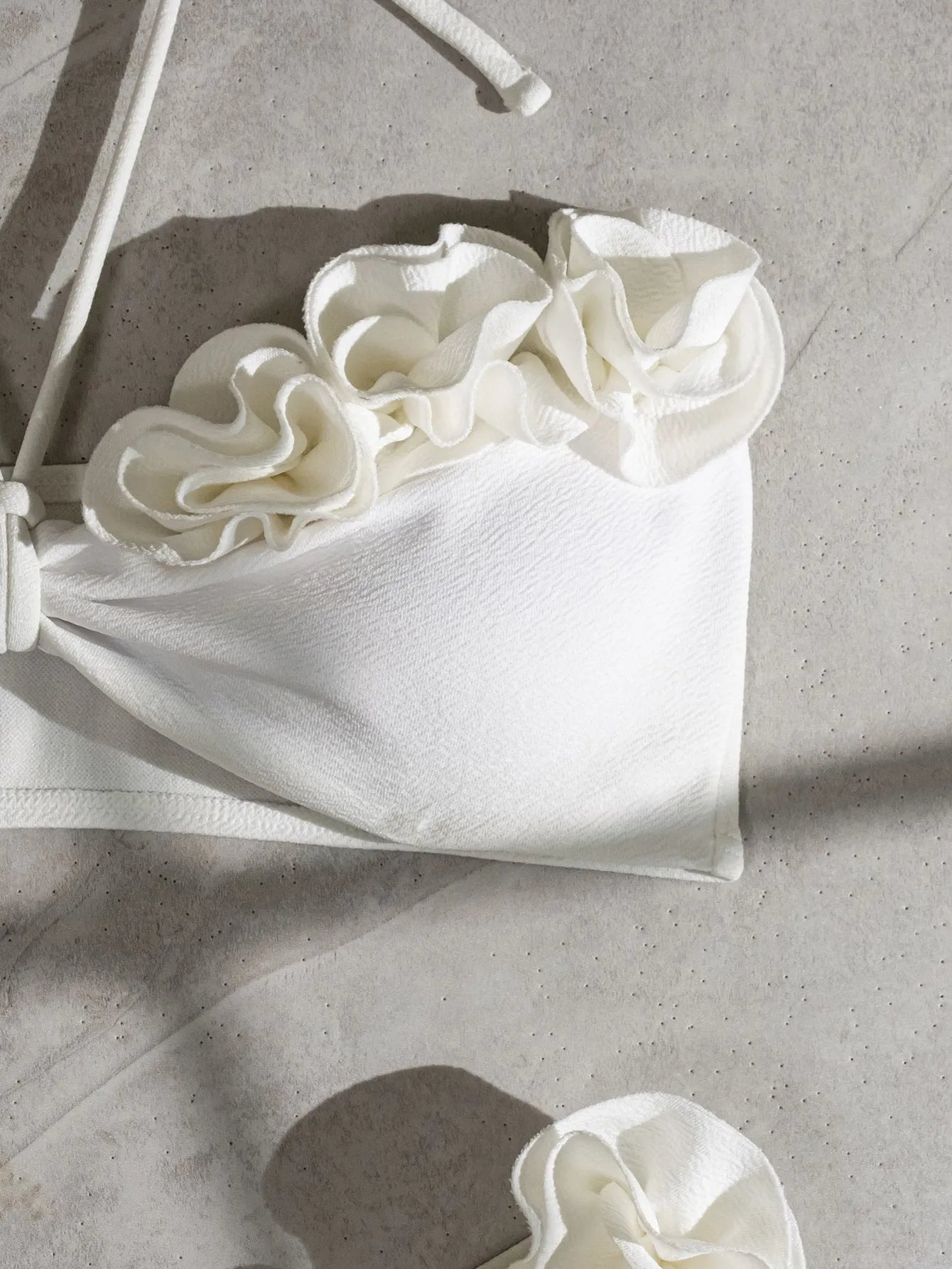 White halter bikini with three-dimensional flower pattern and lace-up detailing