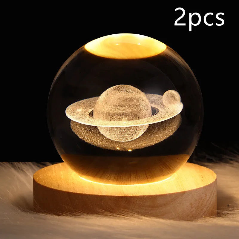 LED galaxy crystal ball night light with 3D planet designs on a table