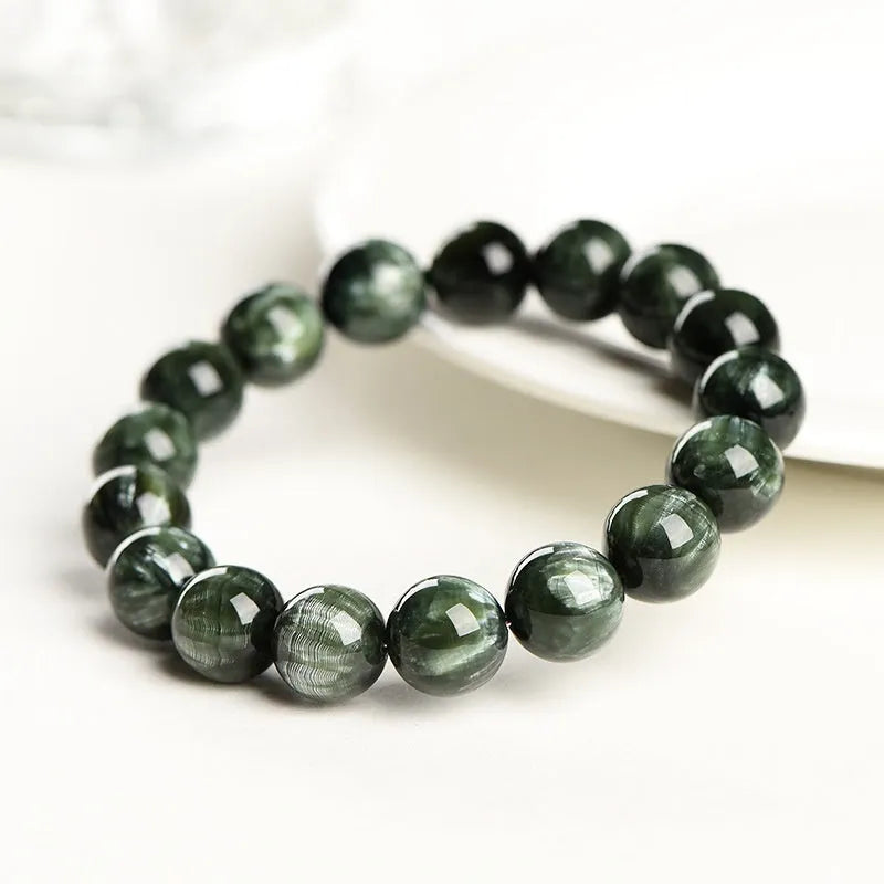 Natural green dragon crystal round bead bracelet with ruyi detail on a white background.