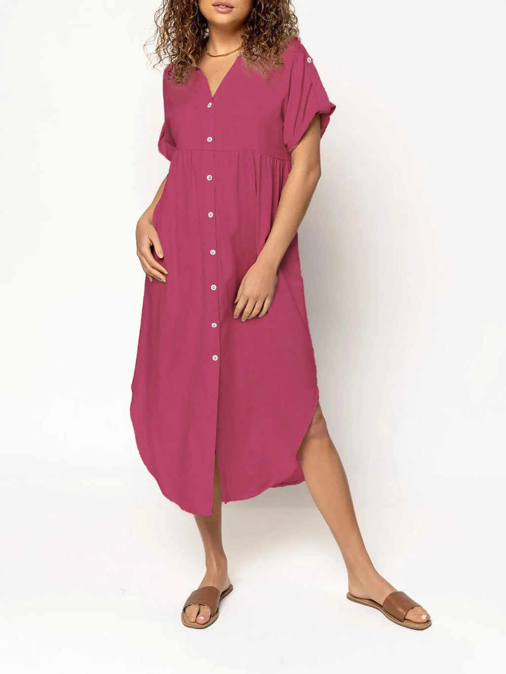 A woman wearing a loose-fitting, solid-colour midi dress with a button-down front and regular sleeves.