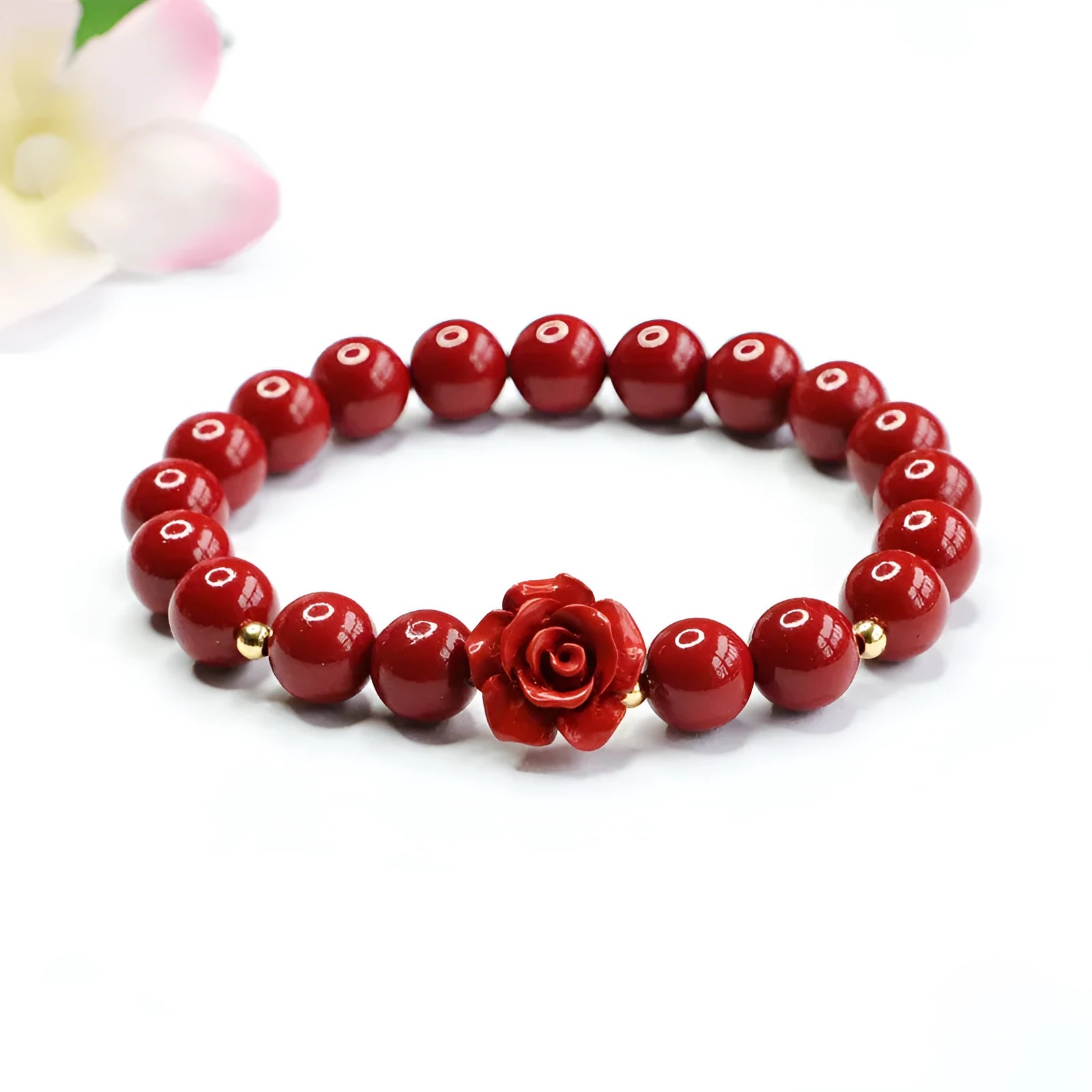 Close-up of a women's natural cinnabar bracelet with a detailed 8mm purple gold sand rose centrepiece.