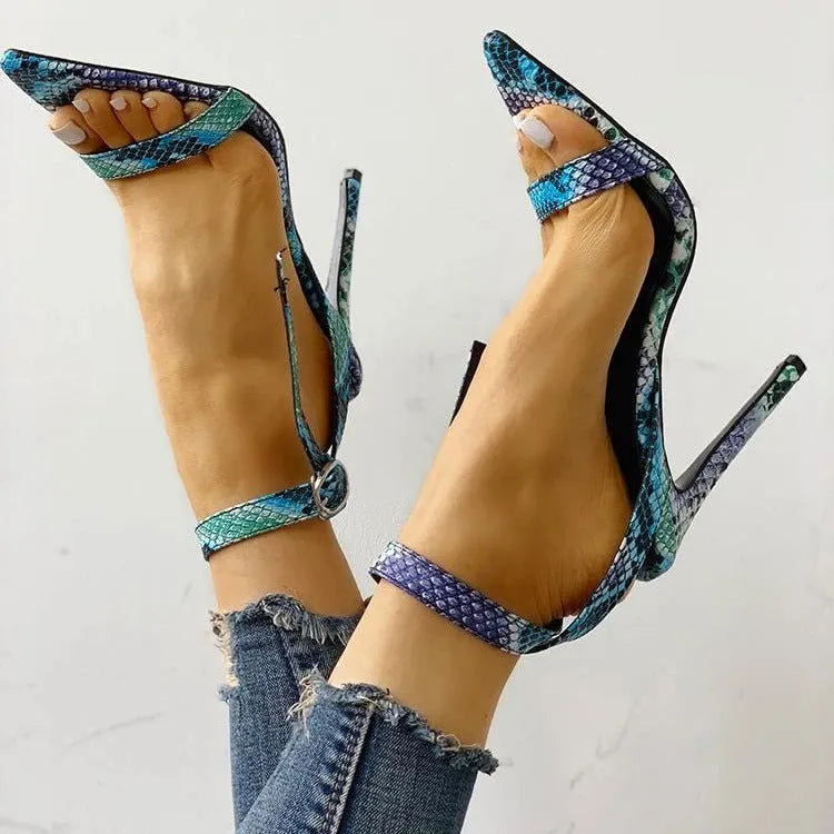 Blue women's high heels with buckle strap and hollow-out design on a pointed toe.