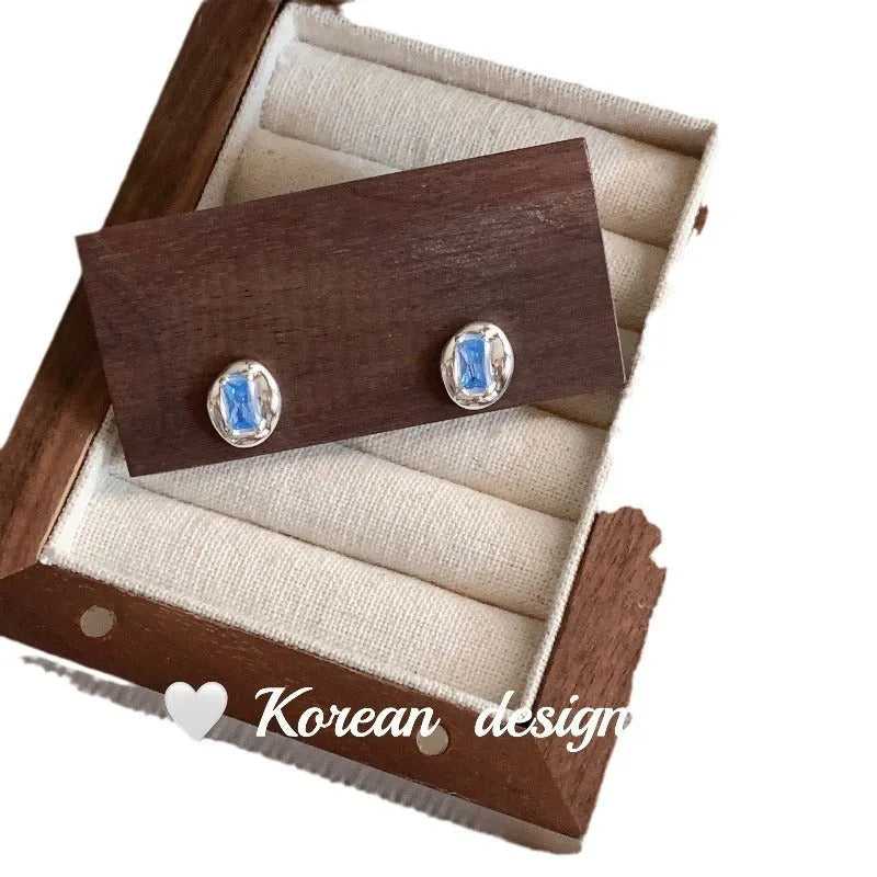 S925 sterling silver earrings with oval blue diamond heart-wrapped geometric design and electroplated silver finish