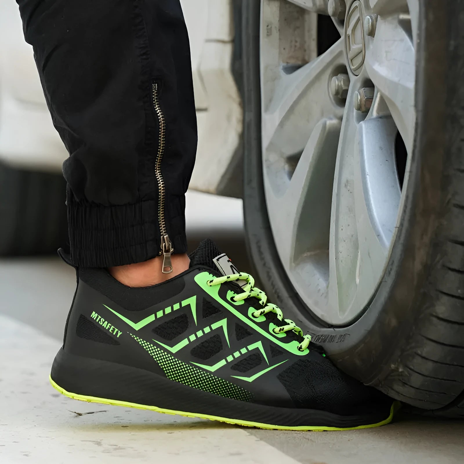 Black lace-up safety shoes with flat knitted uppers and a rubber sole, featuring a steel toe cap.