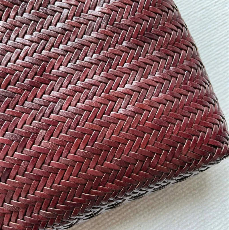 Brown handmade woven leather tote bag with a three-dimensional front pocket.