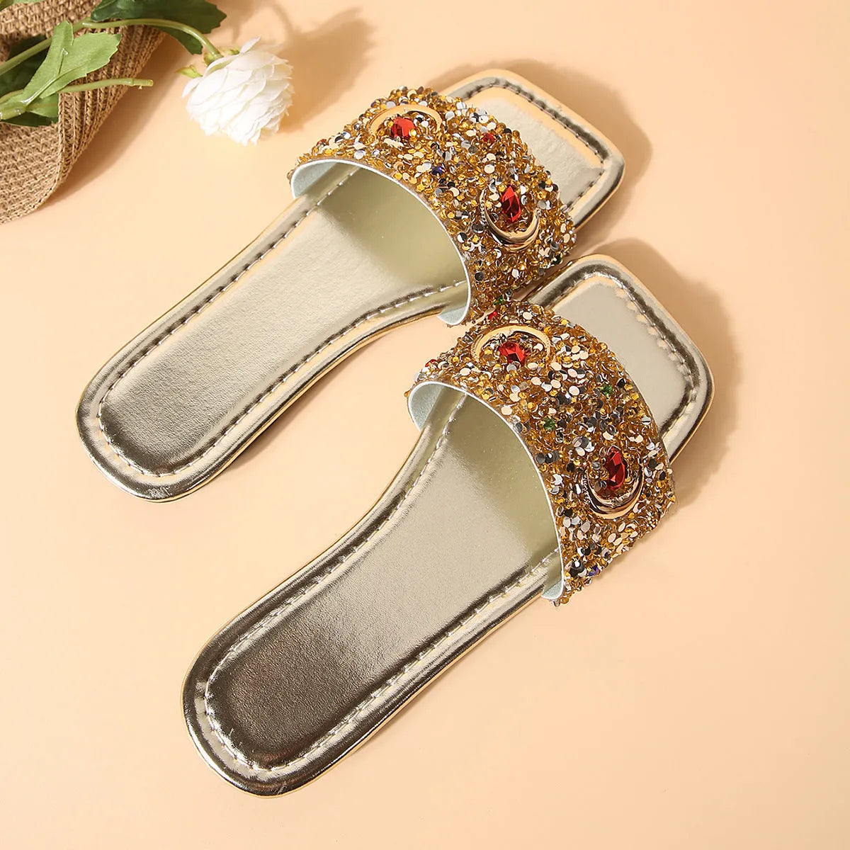Gold women's slippers with rhinestone sequin detailing on flat rubber soles