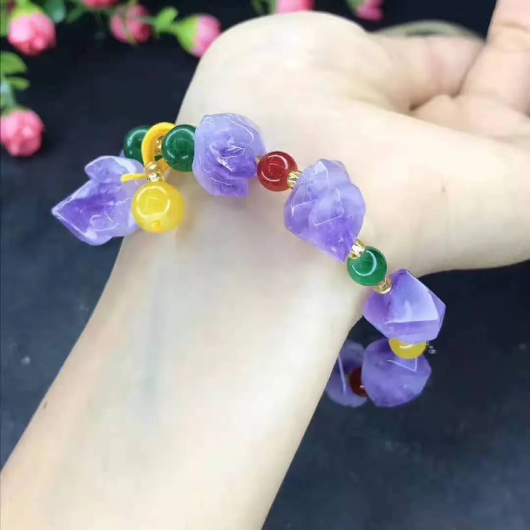Purple amethyst bracelet with natural shaped beads and a fu character charm on a white background.