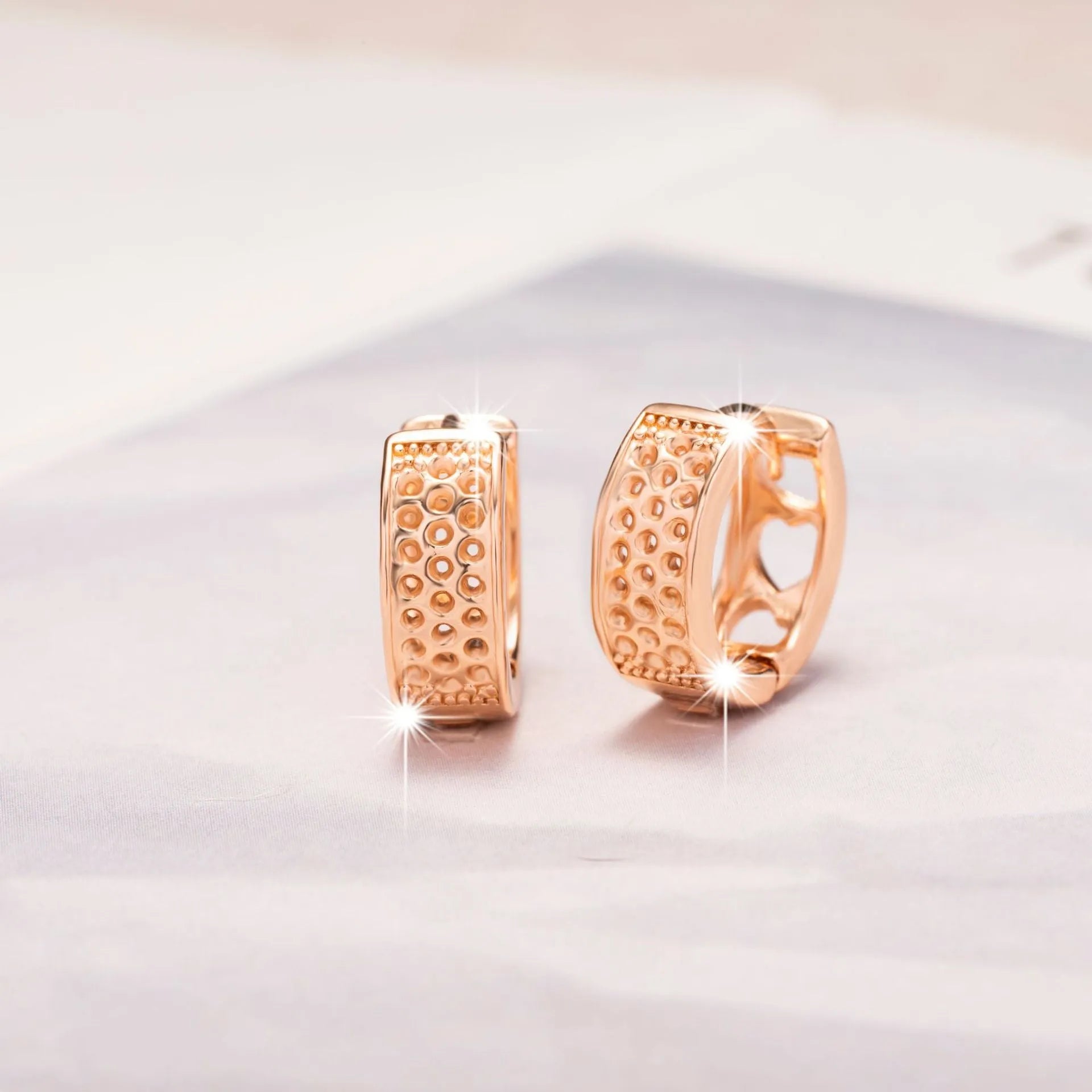 Rose gold women's earrings with three hollow heart shapes in circular arrangement