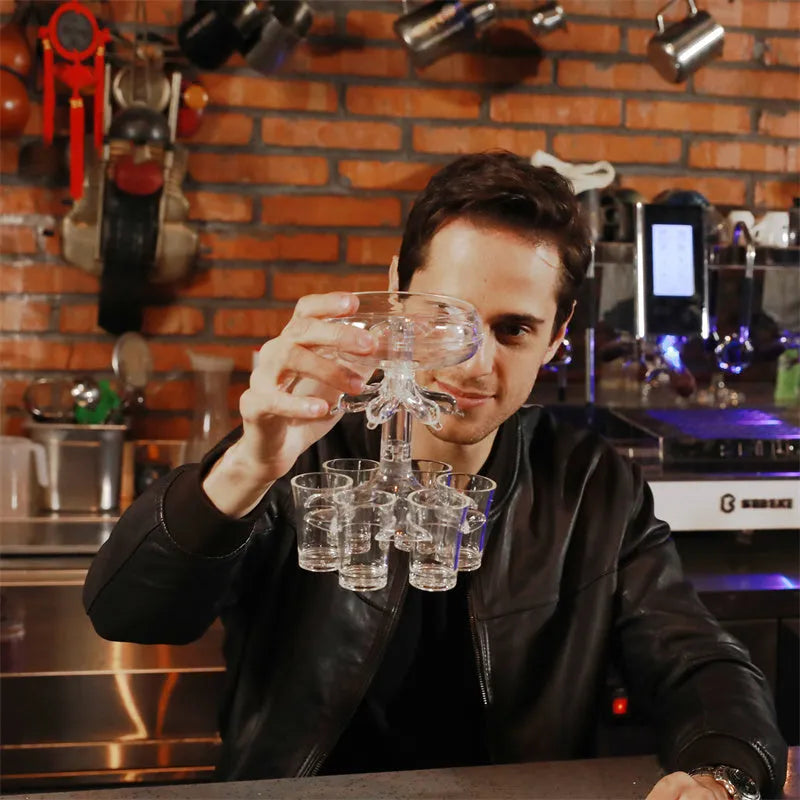 Transparent Plexiglass 6-shot glass dispenser rack holding six cups on a stand.
