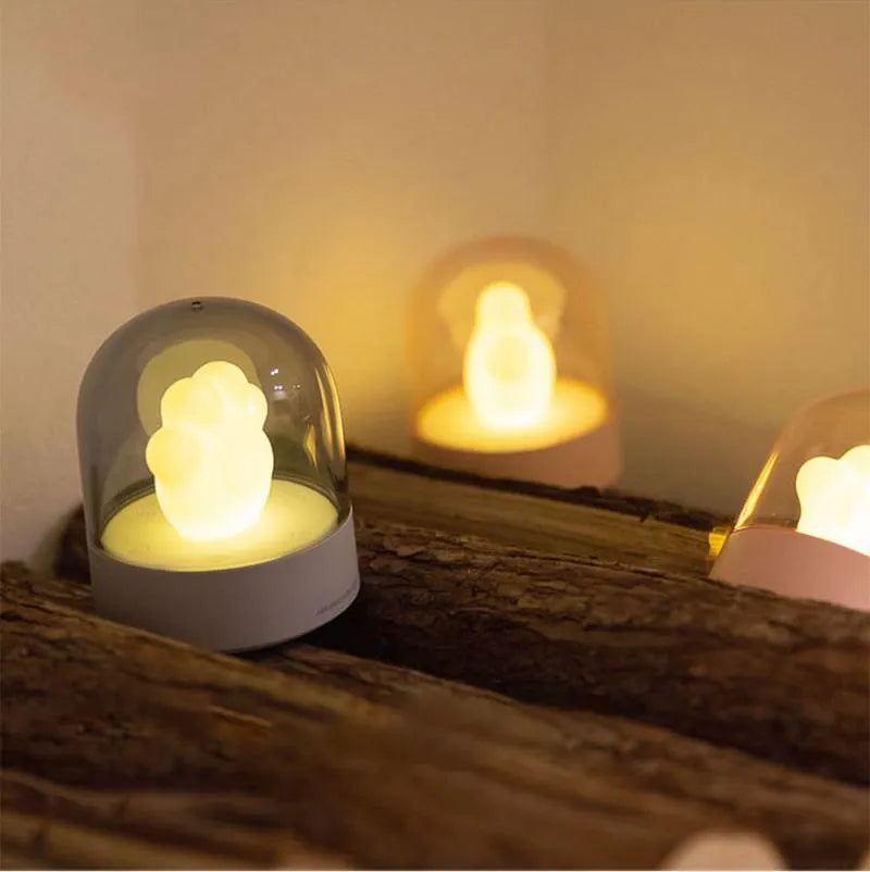 Grey cat paw shaped USB rechargeable night light with musical features on wooden desk