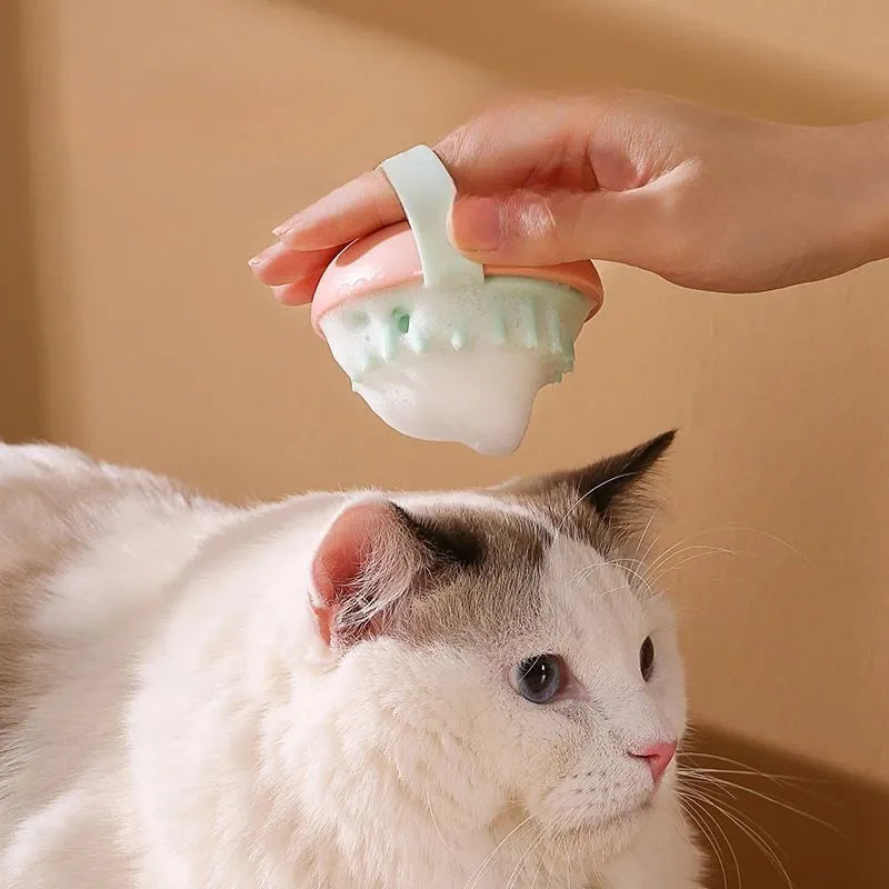 A blue silicone pet bathing brush with soft bristles and a palm-grip base for washing dogs and cats.