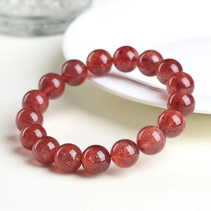 Natural cherry red strawberry quartz bracelet with geometric beads on a wrist