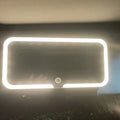 White car sun visor with rectangular LED-lit make-up mirror mounted on it.