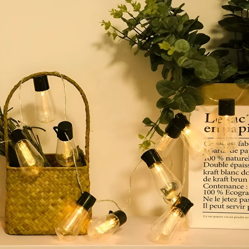 Retro glass infusion bottle shaped outdoor string lights on a patio