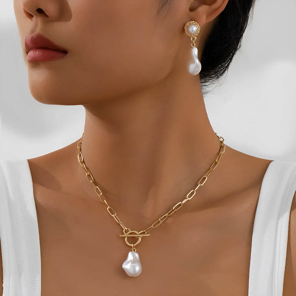 Gold-tone baroque pearl pendant necklace and matching stud earrings set on a white background.