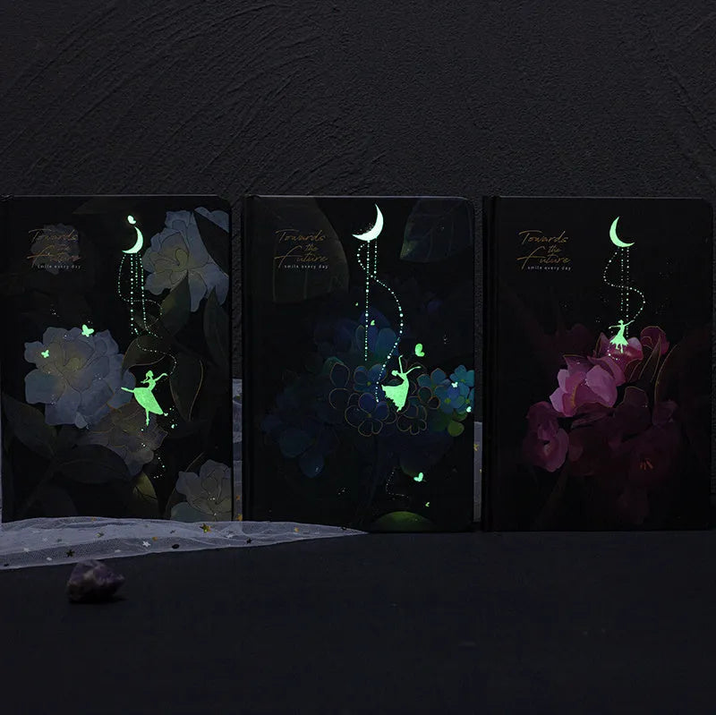 A5 diary book with a luminous purple cover, open to show pages with colour illustrations.