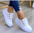 Women's white lace-up flats sneakers with decorative silver rivets on the artificial PU upper.