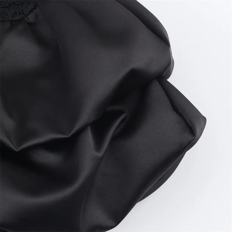 Women's black cotton short dress with lace stitching and asymmetric skirt on a plain background