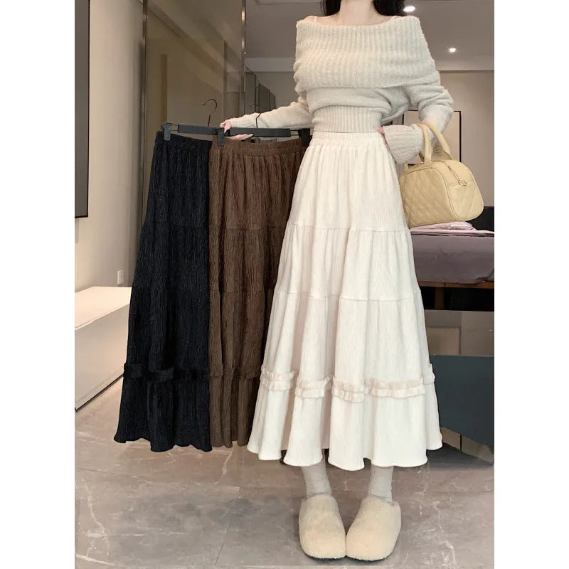 A slimming milky white corduroy A-line midi skirt with an elastic waistband laid flat.