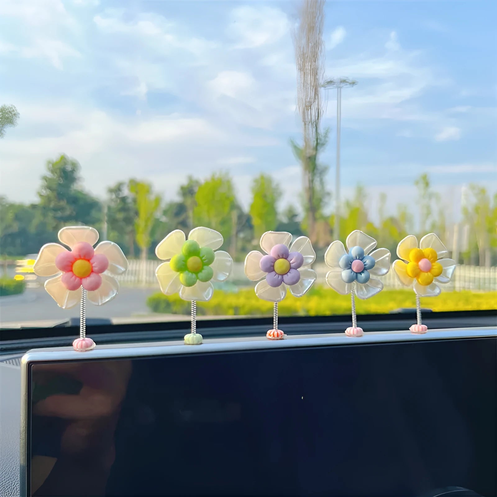 Small colourful plastic swing car decoration for dashboard or mirror.