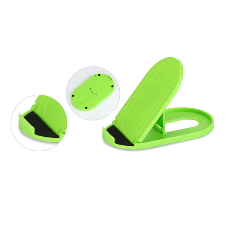 Plastic lazy bracket mobile phone stand in six colour options holding a smartphone on a wooden desk.