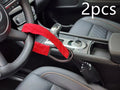 Red car steering wheel lock with iron cable secured around a steering wheel.