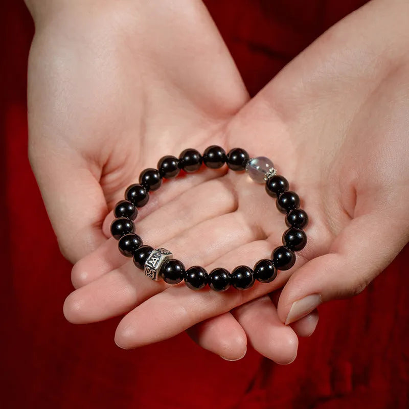 Black obsidian bracelet with 8mm beads carved with Zodiac animal and Buddhist bodhisattva designs.
