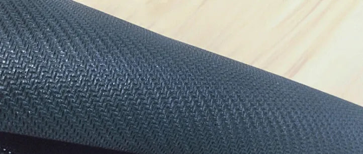 Large desk pad with printed pattern on a wooden desk, showing non-slip rubber base.
