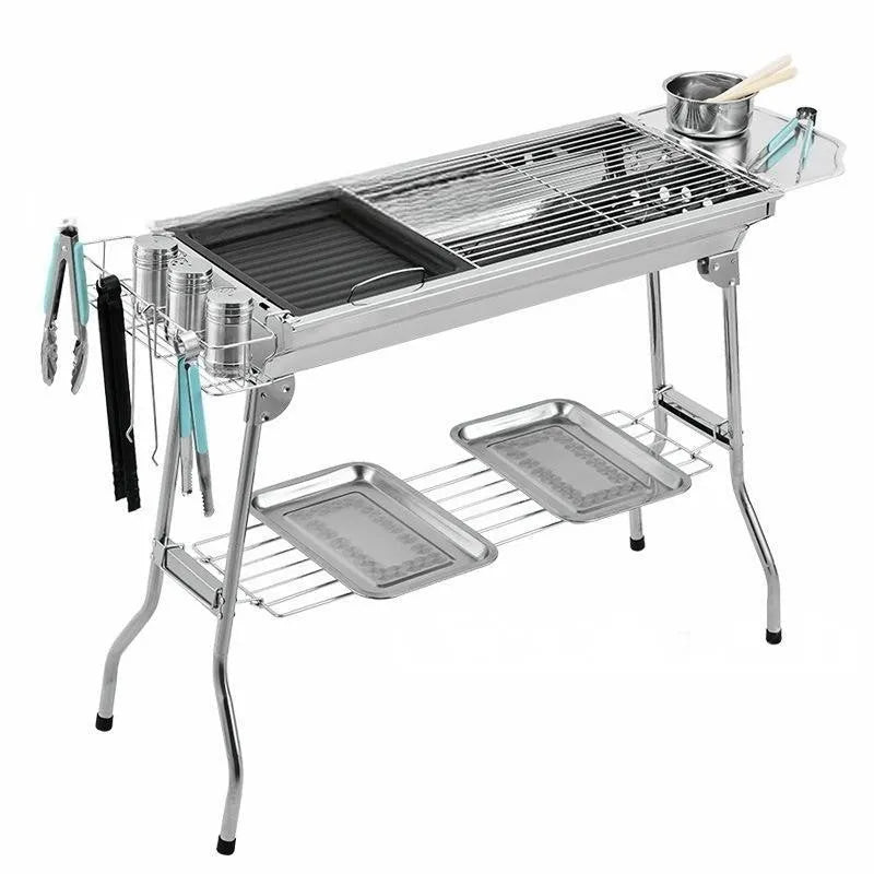 Stainless steel portable folding barbecue oven set up outdoors.