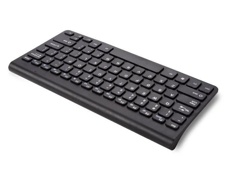 Black and white wireless keyboard and mouse set with USB receiver on a wooden desk.