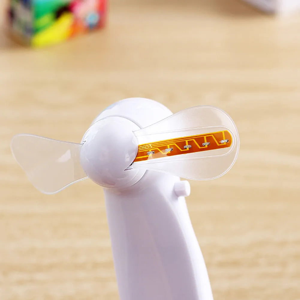 White handheld mini fan with blue and red LED love pattern flashing on its front