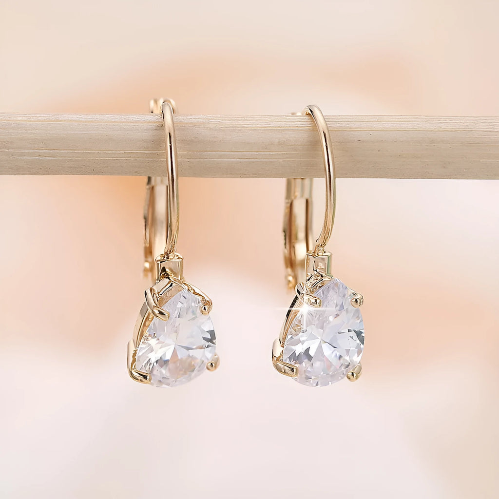 Women's drop-shaped metal earrings in gold or platinum colour with inlaid gem details