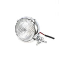 Black circular aluminium Harley-style motorcycle headlight with a coloured glass lens.