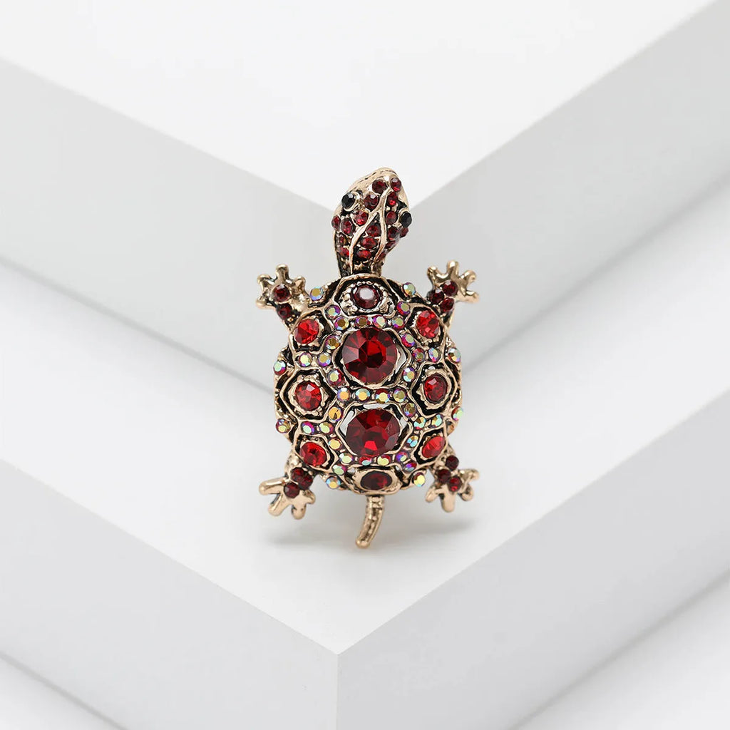 Close-up of a retro-style rhinestone turtle brooch in alloy, shown in blue, green and red colour options.