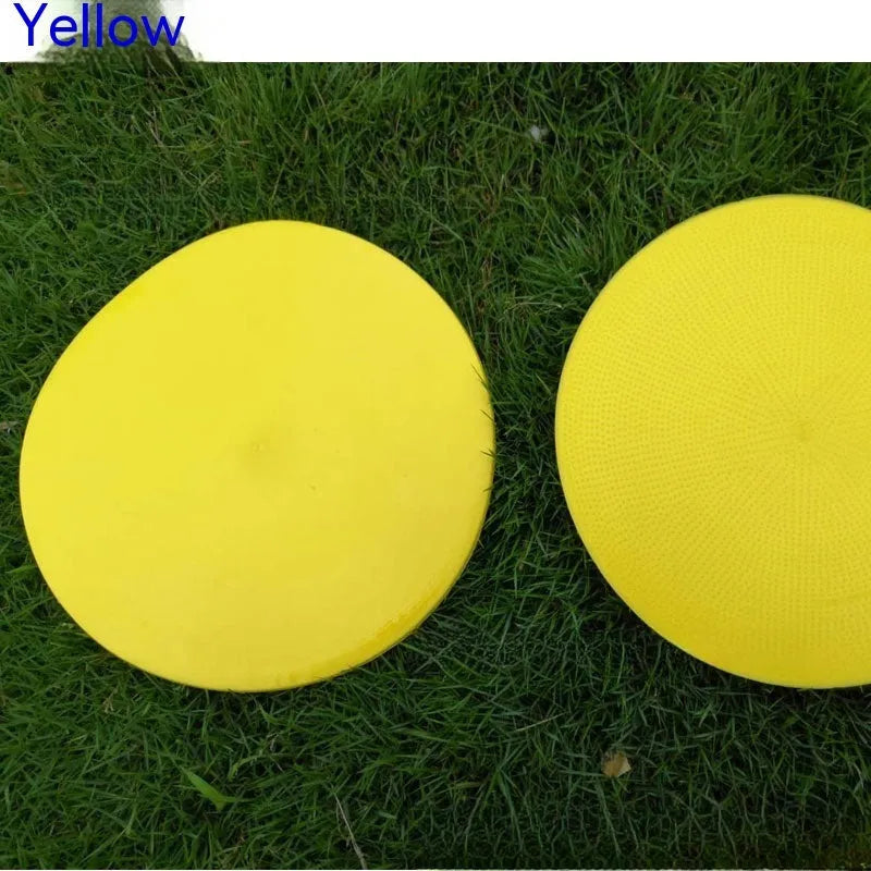 Yellow TPE football training landmark pad, 23cm diameter flat disc on grass.