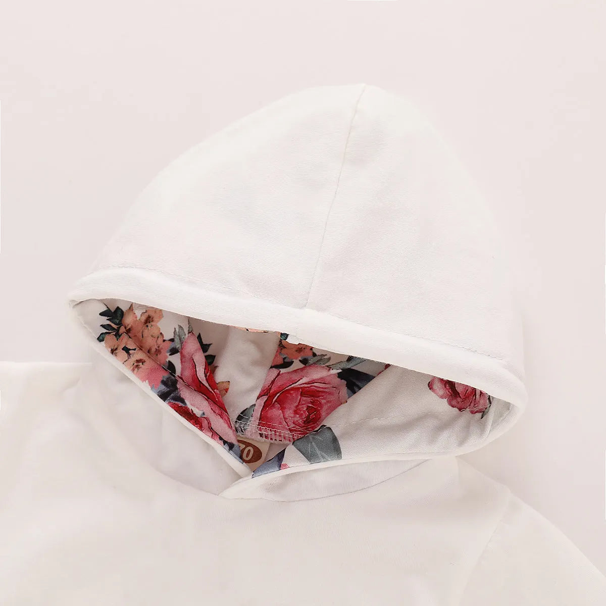 White print hooded romper suit for baby girls made from soft cotton with long sleeves and trousers.
