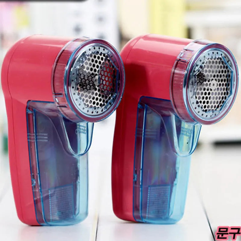 Portable electric lint remover shaver for clothing on a blue background.