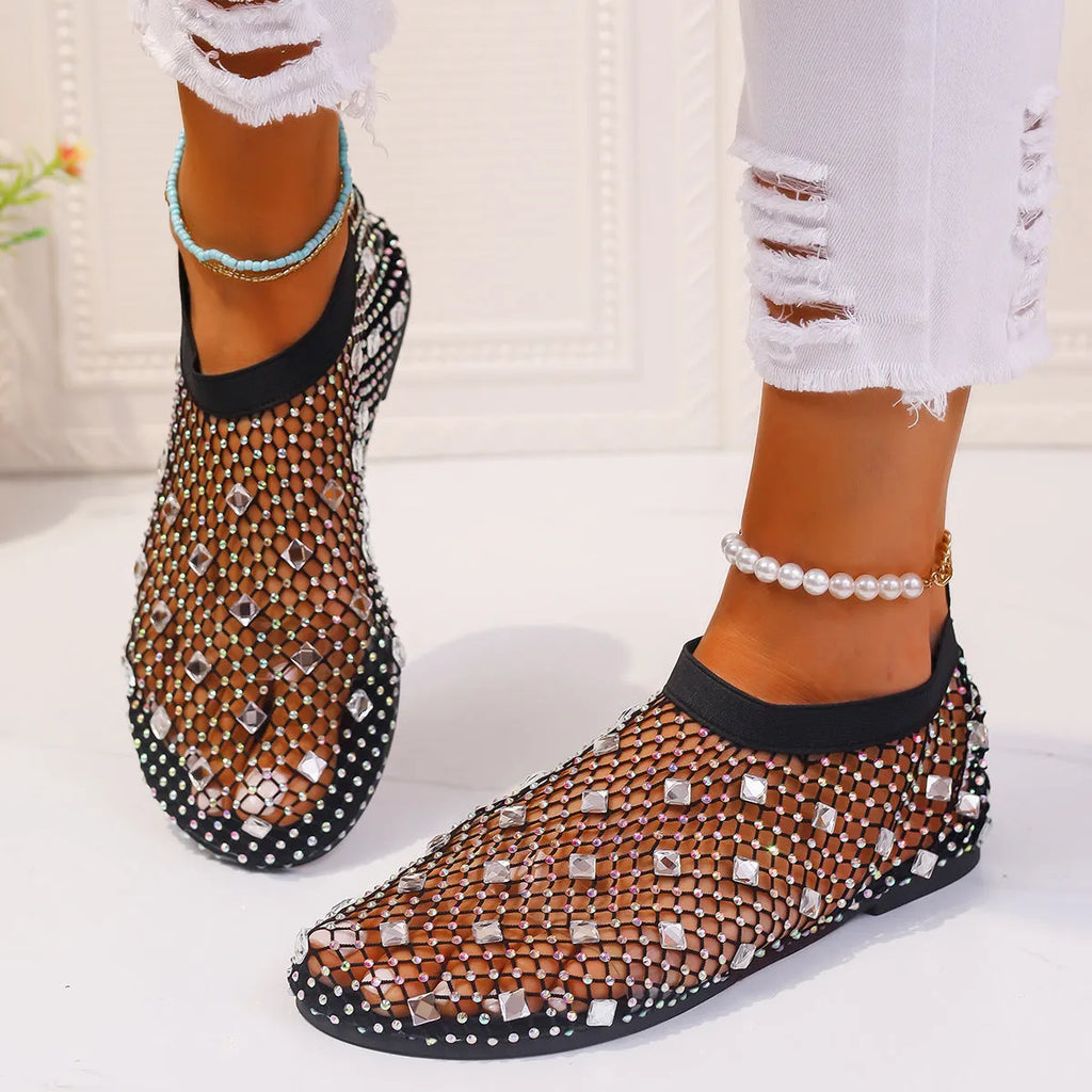 Women's flat sandals with colourful rhinestones on a breathable mesh upper and rubber sole.