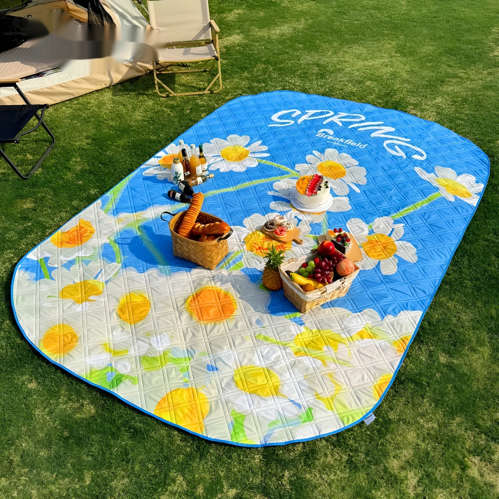 Large waterproof outdoor picnic mat in a seasonal colour, laid out on grass.