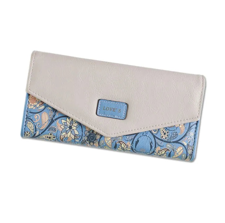 Women's large black tri-fold leather wallet with a buckle closure and a silver money clip inside.