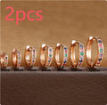 A pair of perforated circular stud earrings with zircon detailing in gold, rose gold, or silver colour.