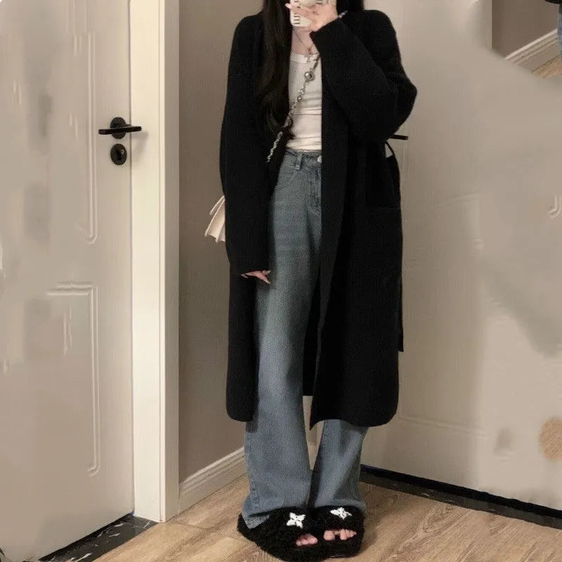 Woman wearing a loose, thick-knit chenille cardigan in a solid colour, showing the long sleeves and casual fit.