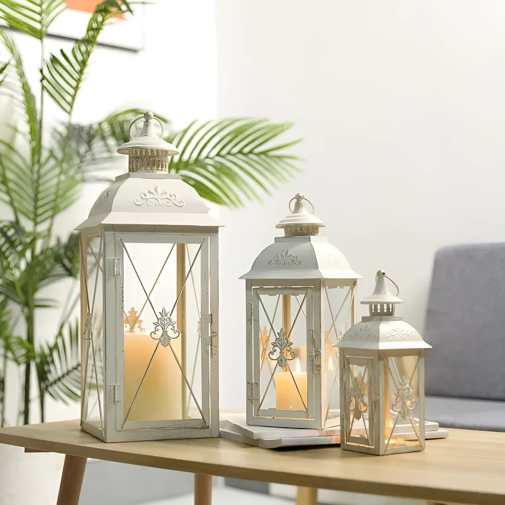 Black and white wrought iron floor storm lantern with tempered glass panels for courtyard decoration.