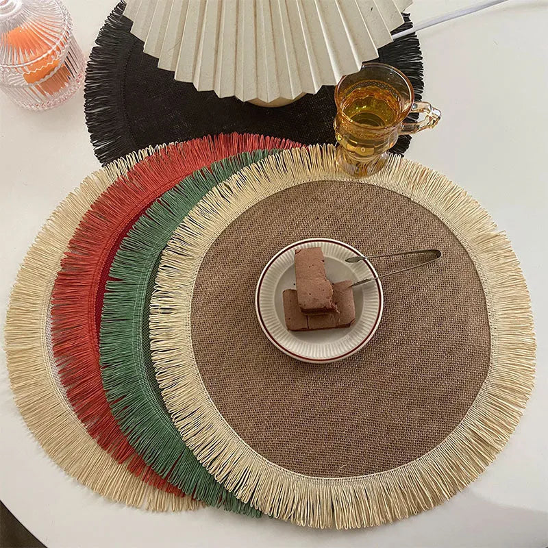 Handwoven round jute placemat with tassel edge in original hemp colour on a wooden table