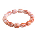 Natural cherry agate bracelet with barrel-shaped beads and a gold Ruyi charm on an adjustable strap.