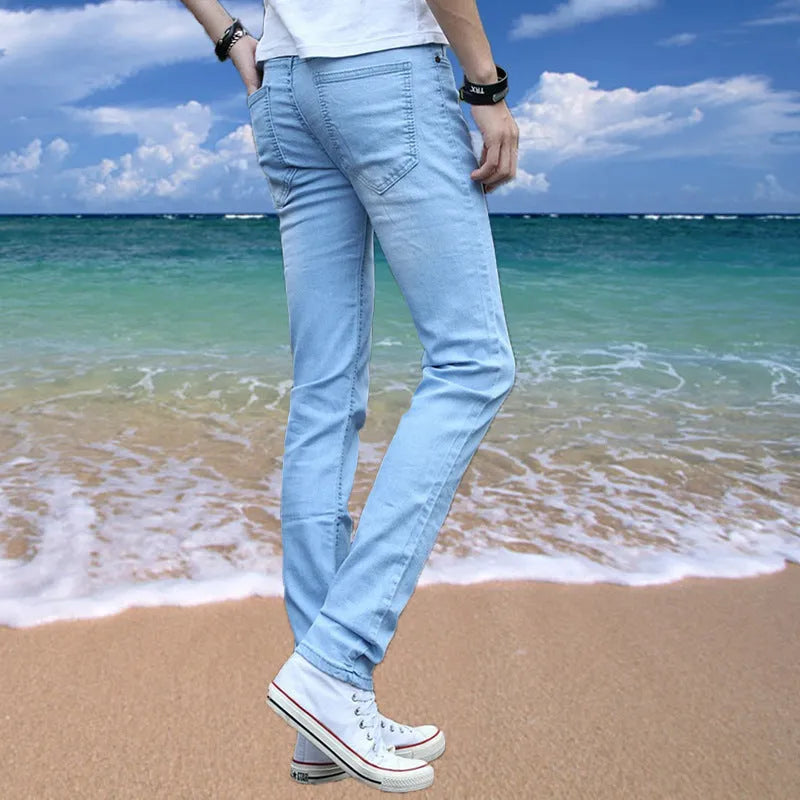 Thin men's loose skinny casual jeans in pure black with low waist, cropped leg, small leg opening, and zip fly.